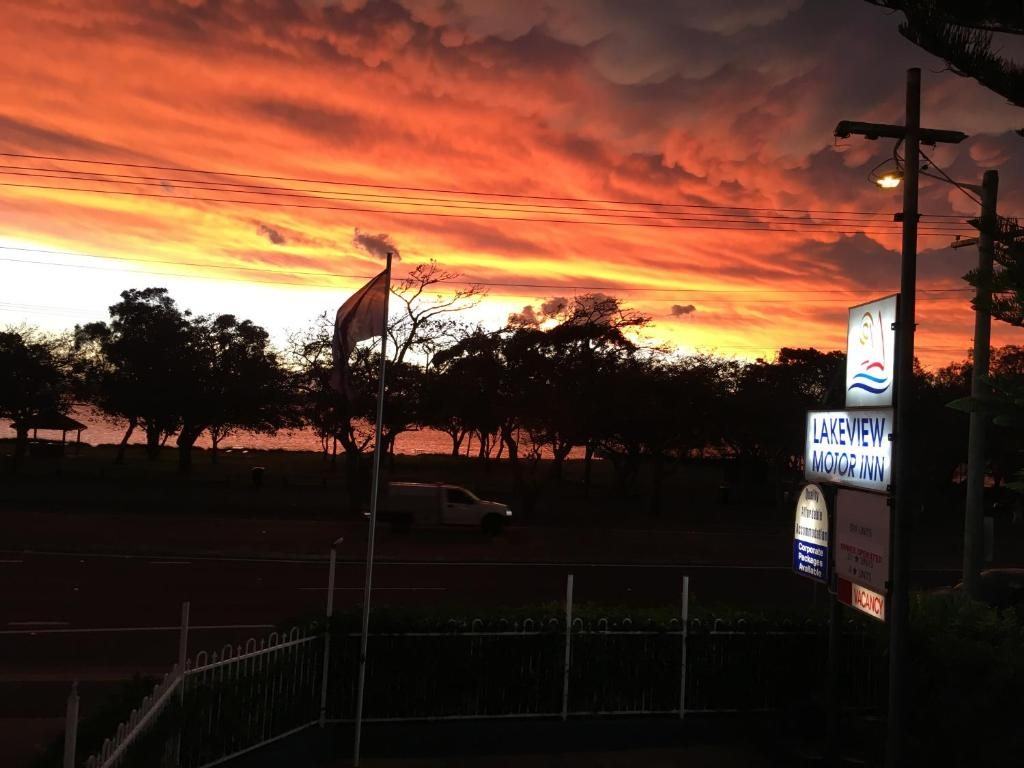 The Lakeview Motor Inn sign against a red sunset over Lake Macquarie, Belmont South NSW